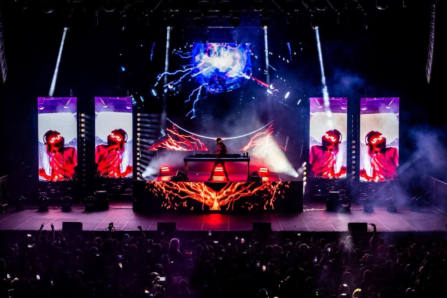 Festival mainstage with LED towers and pyrotechnics over a large crowd